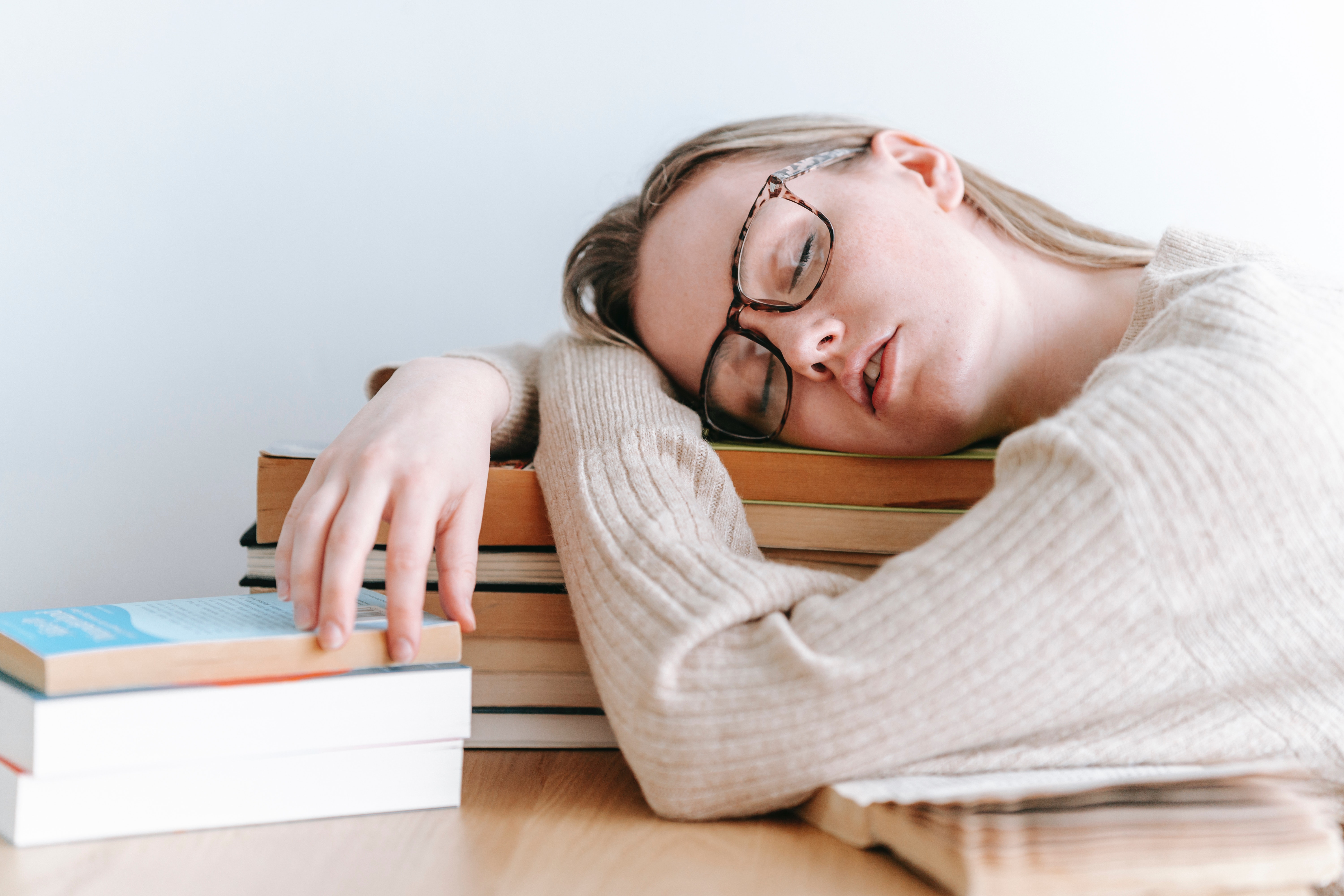Une femme endormie sur une pile de livre